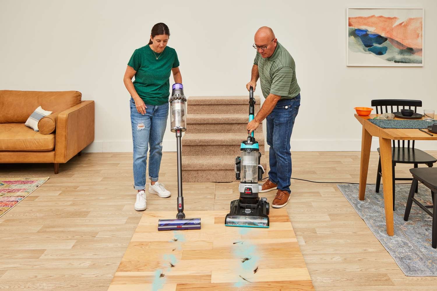 Cordless stick vacuum resting on light oak hardwood floor in a bright living room