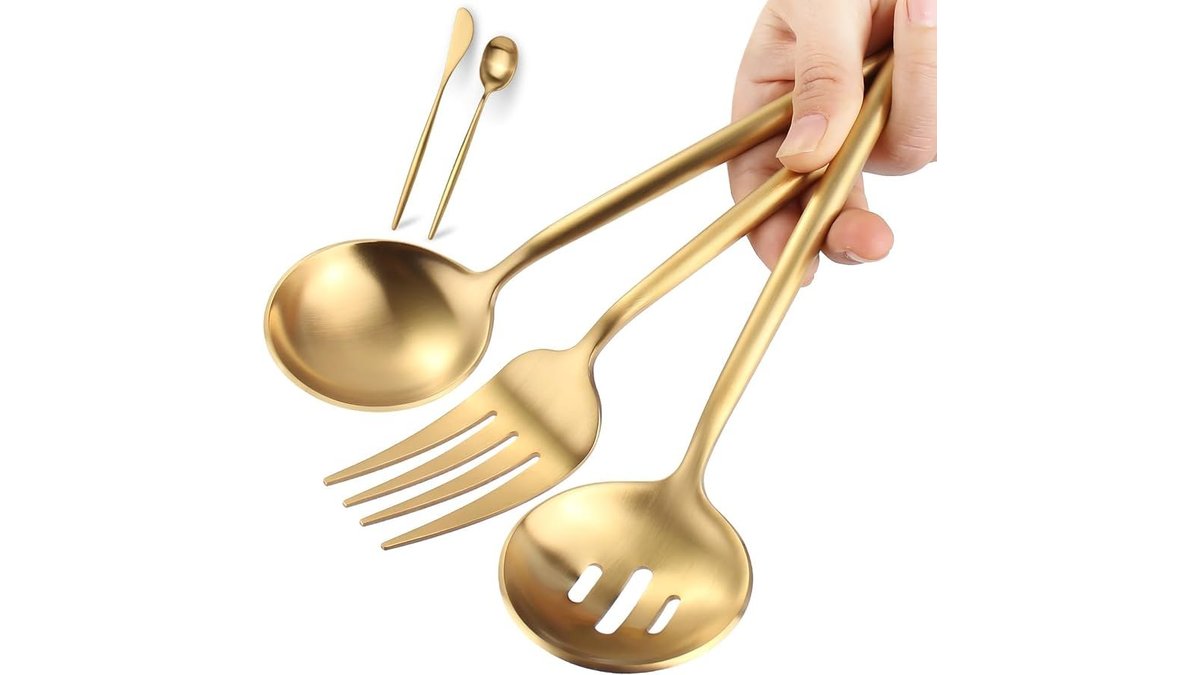 An elegant gold stainless steel kitchen utensil set displayed on a marble countertop.