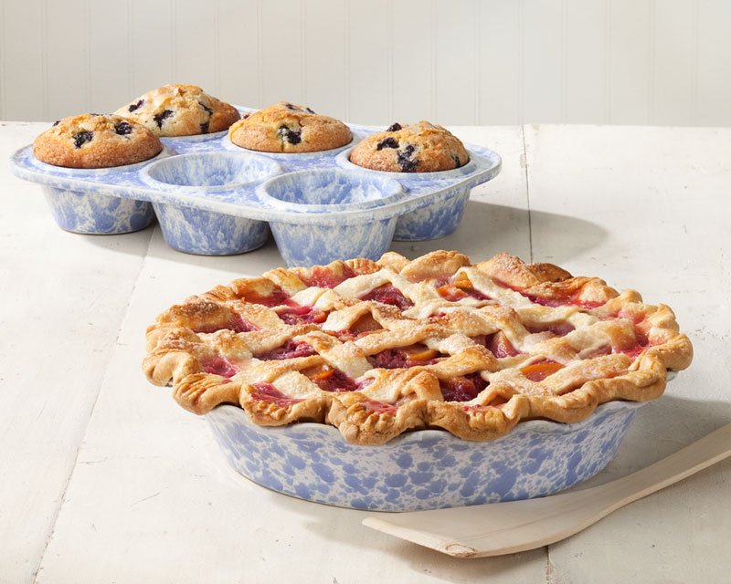 A freshly baked pie in a ceramic pie dish on a wooden kitchen counter.