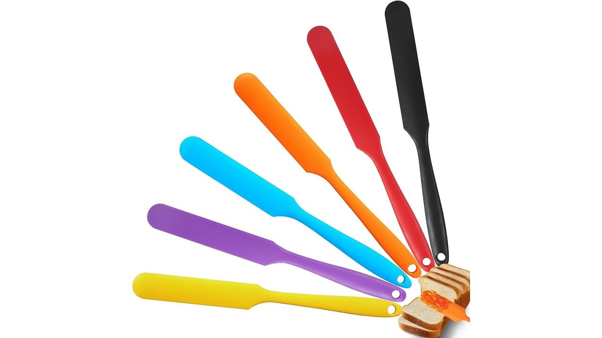 Heat resistant silicone jar spatula set arranged on a wooden kitchen counter.