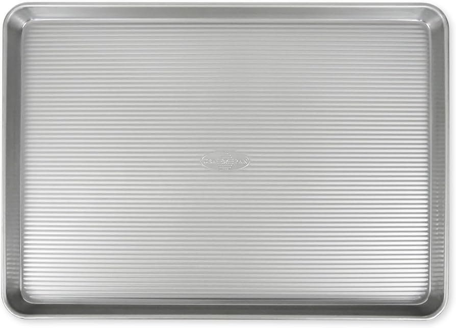 A high-quality aluminized steel baking sheet pan sits on a modern kitchen counter.