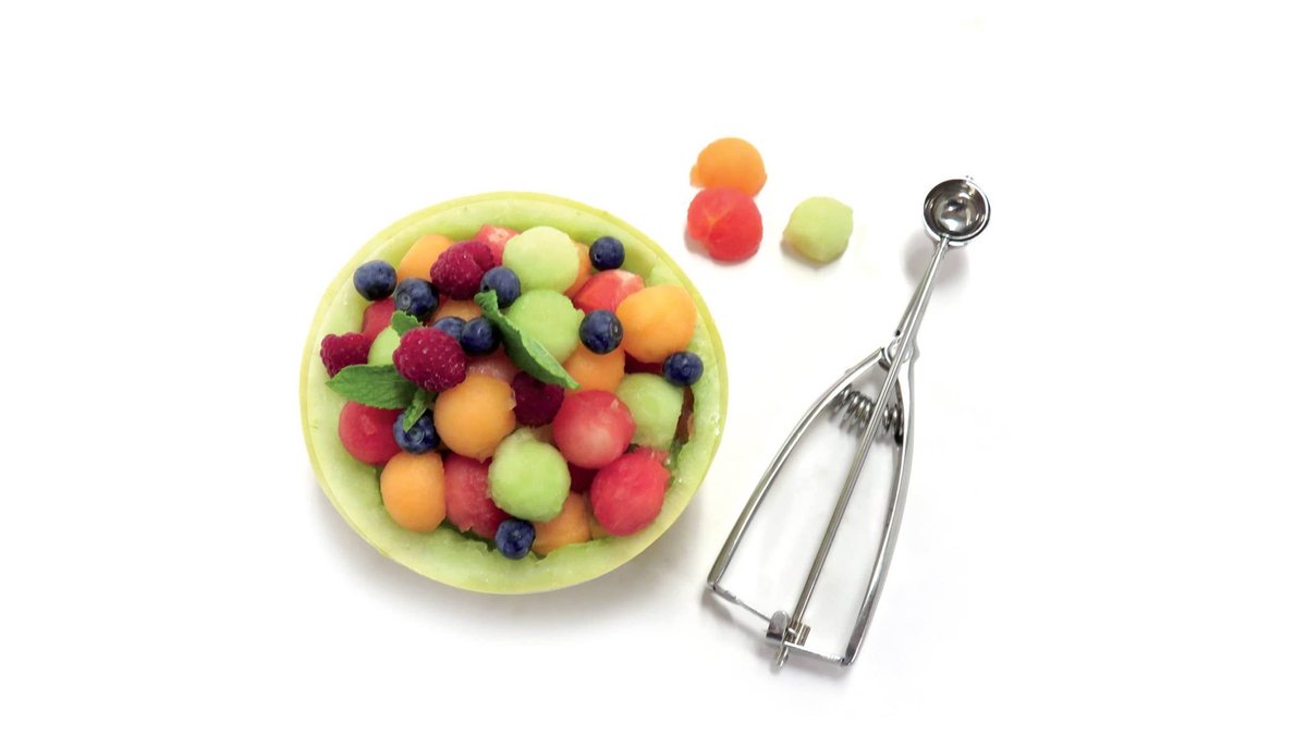 A mini ice cream scoop next to a small vanilla scoop in a bowl.