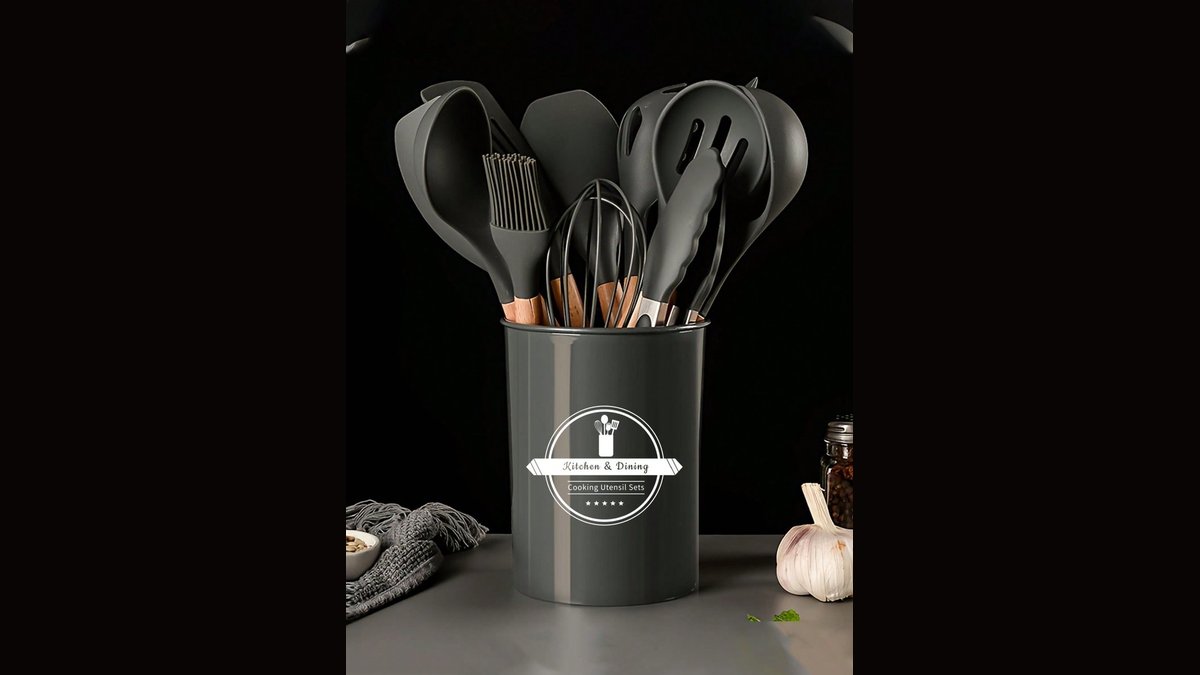 A polished stainless steel cooking tools set in a matching bucket on a marble counter.