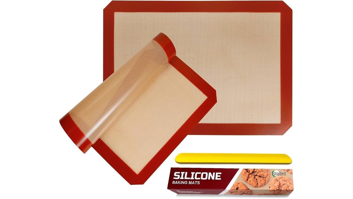 A set of silicone baking mats arranged on a marble counter for baking.
