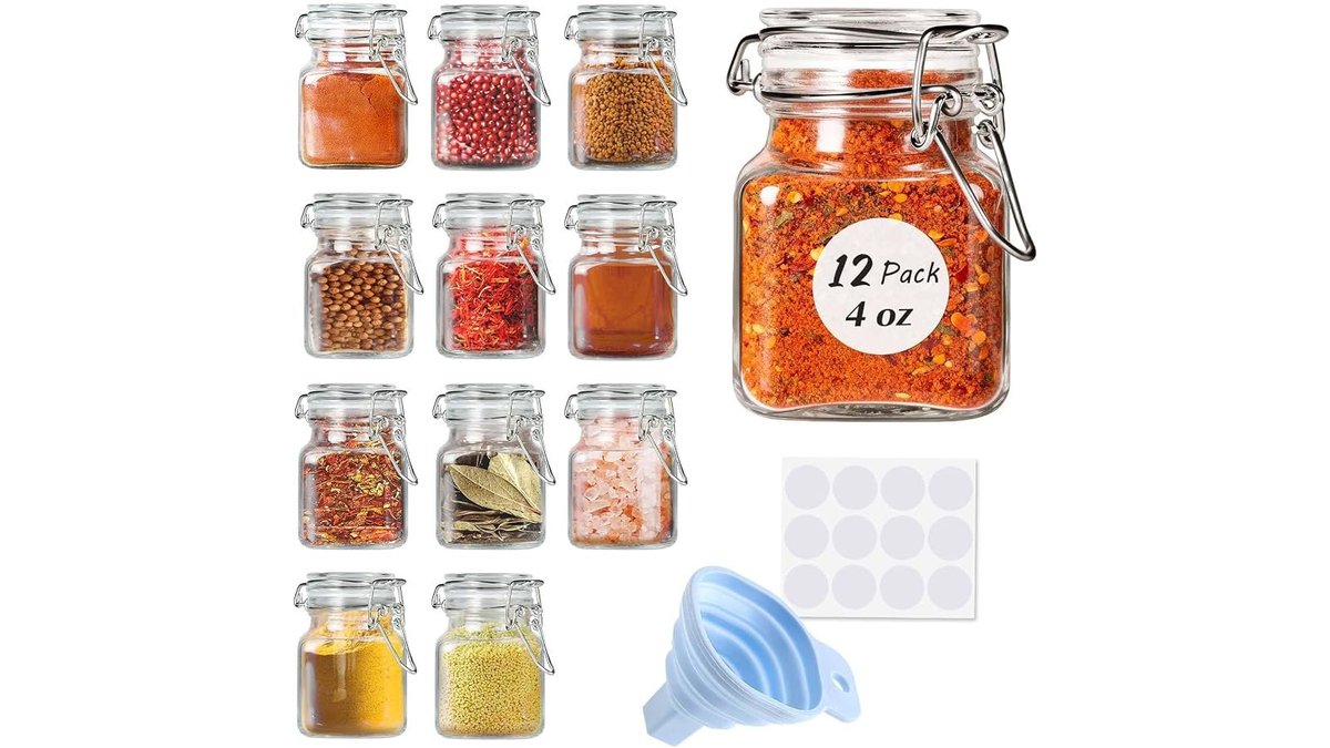 Small metal funnel resting in a glass spice jar on a wooden counter