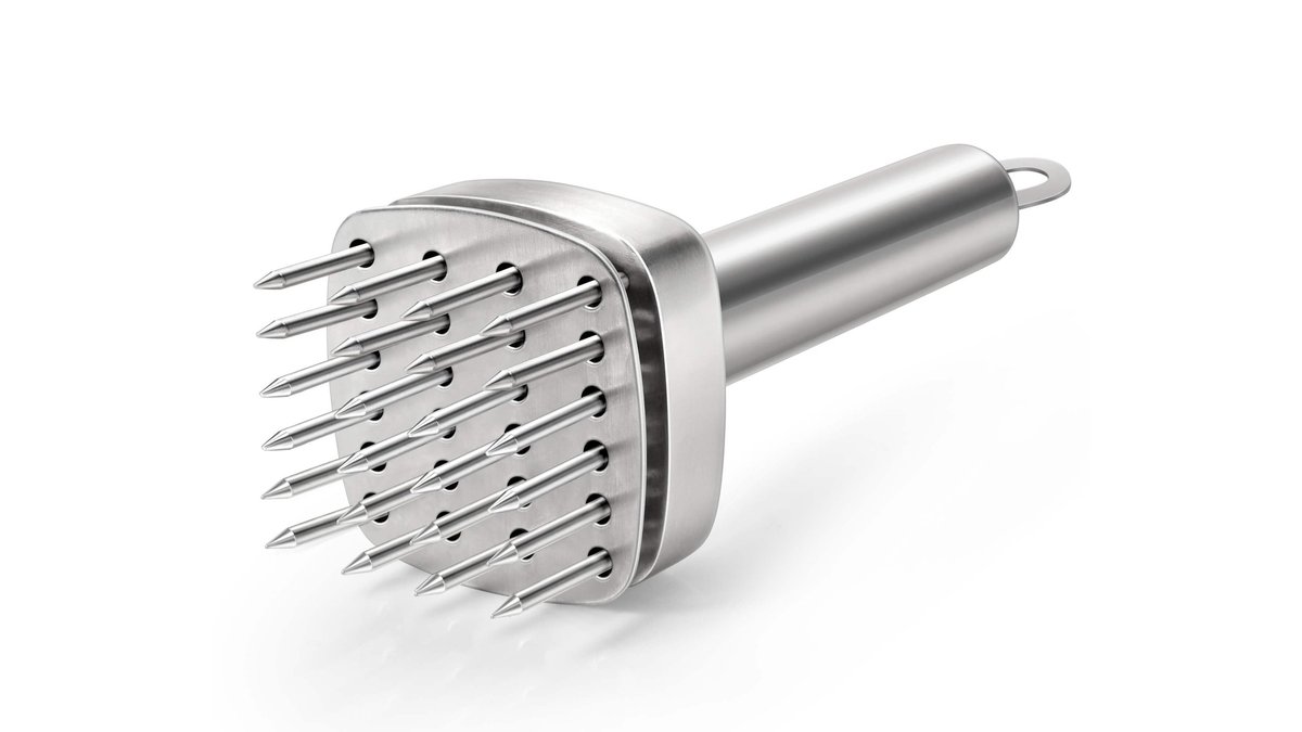 Stainless steel needle meat tenderizer tool rests on a wooden board near raw beef.