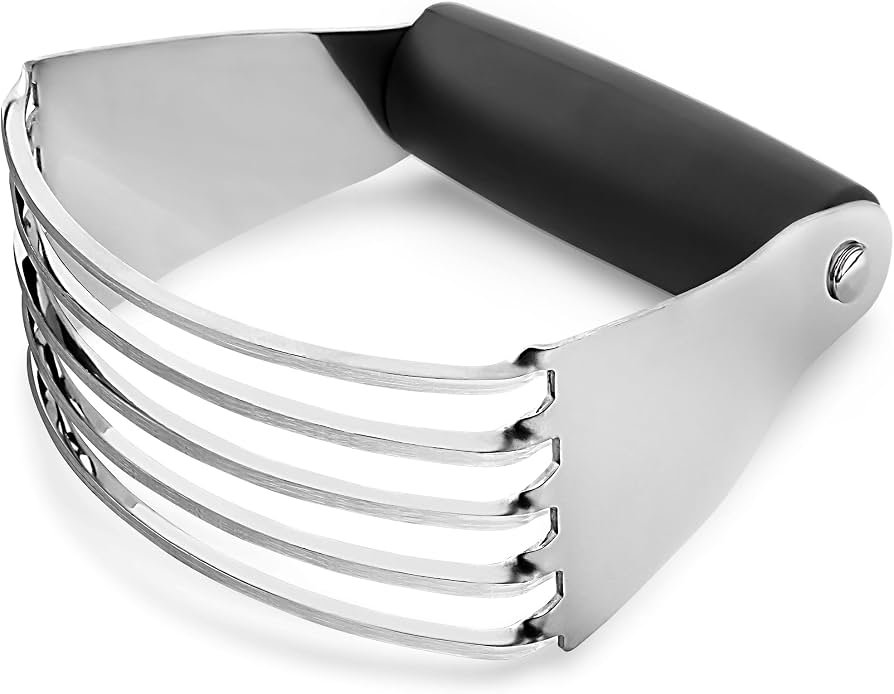 A stainless steel pastry cutter and dough blender resting on a floured marble countertop.
