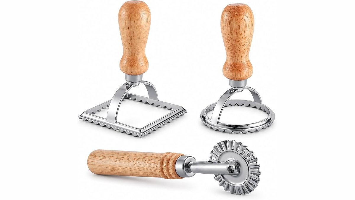 Stainless steel ravioli maker stamp cutter set on a light wood counter in a sunlit kitchen.