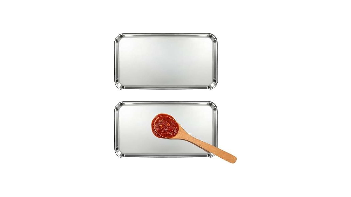 A stainless steel spoon rest with drip pad on a clean marble countertop.