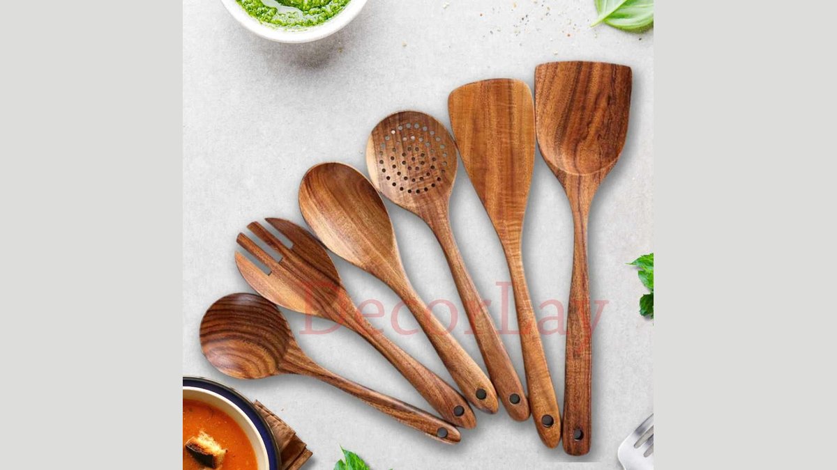 Wooden spoon set resting on nonstick cookware in soft natural kitchen light